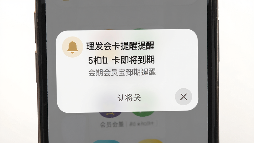 一张理发会员宝到期提醒功能的界面图,画面主体是手机屏幕弹出提醒通知,通知内容显示会员卡即将到期,布局为顶部弹窗式,风格为柔和圆角卡片风,细节包括铃铛图标、提醒文字和关闭按钮,画质高清,干净,无多余元素