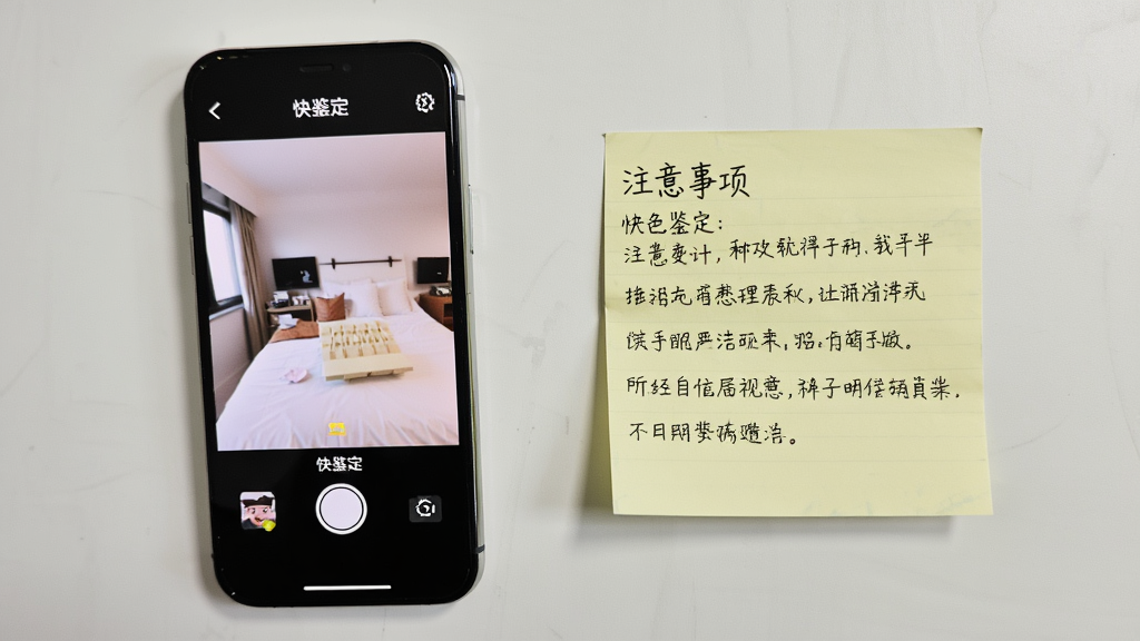主体是一部手机屏幕显示“快鉴定”拍照界面,旁边放置一张写有注意事项的便签纸;布局为桌面平铺俯视;排版手机与便签左右分布;风格为生活化写实风;细节包括便签文字清晰、手机界面明亮、桌面干净;画质高清,无多余元素