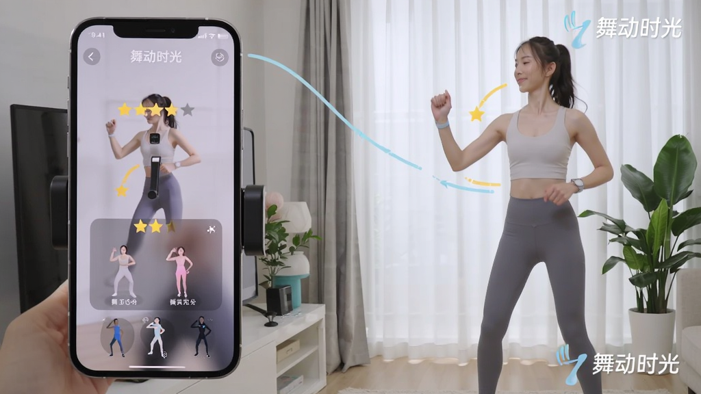 一名女性使用手机支架在客厅跟随“舞动时光”跳舞,画面左侧为手机屏幕特写,显示评分与动作提示,右侧为女性全身动作,背景有干净窗帘与绿植,布局左右分明,风格自然生活化,细节包含动作轨迹线、评分星级与“舞动时光”文字水印,画质清晰干净,无多余元素