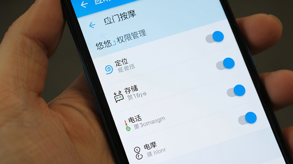 手机屏幕显示应用权限管理页面,包含定位、存储、电话等权限开关,界面风格为安卓原生设置风格,配色为白色与浅蓝色,画质清晰,画面中有