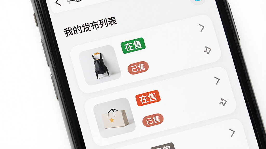 闲置二手转手个人中心管理页面,主体为手机屏幕,显示我的发布列表,每个物品卡片上有状态标签如“在售”、“已售”,布局为垂直列表,风格清爽极简,细节上卡片有圆角,状态标签颜色醒目,背景为纯白色,画质高清,干净,无多余元素