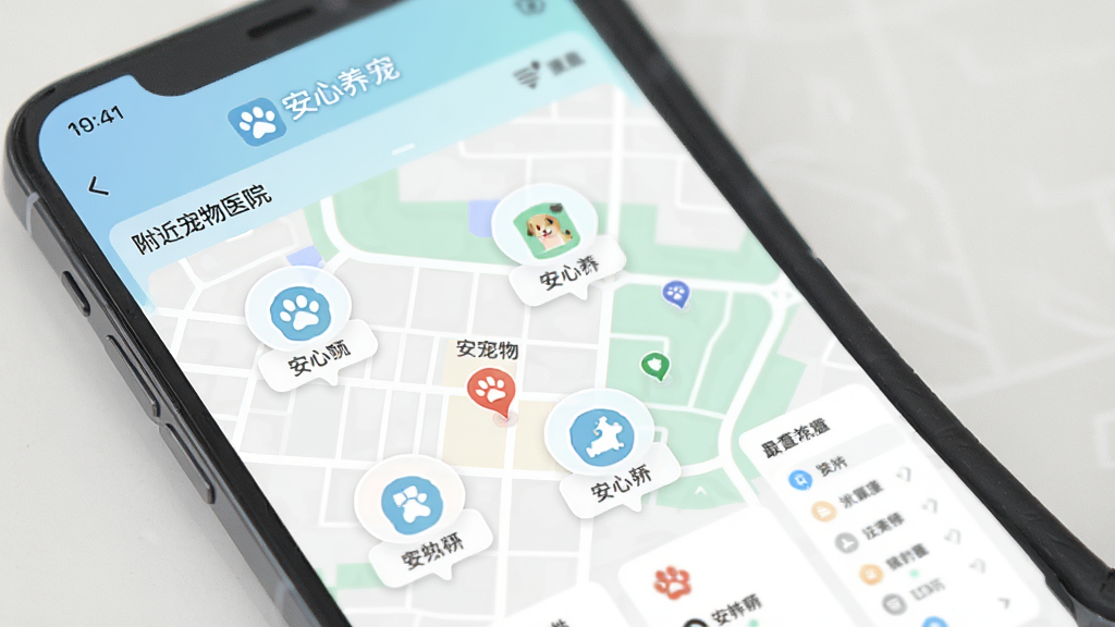 手机界面展示安心养宠APP的社区页面和附近宠物医院列表,地图上标注着多个服务点图标,界面设计简洁现代,配色柔和,画质干净,文字清晰可见“安心养宠”品牌标识,无多余元素