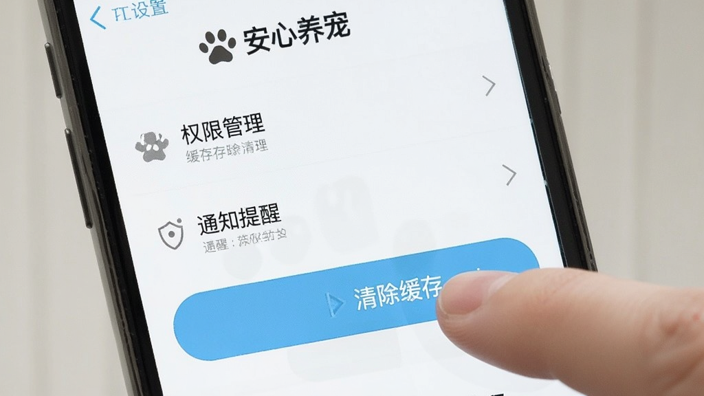 手机屏幕显示安心养宠APP的设置页面,页面中可见权限管理、缓存清理、通知提醒等选项,旁边有手指正在点击“清除缓存”按钮,画面风格简洁直观,配色清爽,画质干净,突出“安心养宠”界面文字,无多余元素